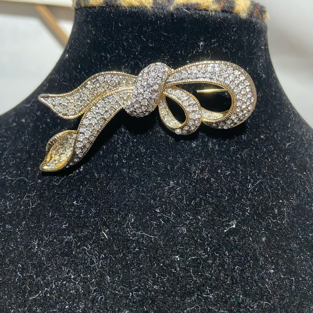 Gold Tone Ribbon Brooch With Rhinestones.